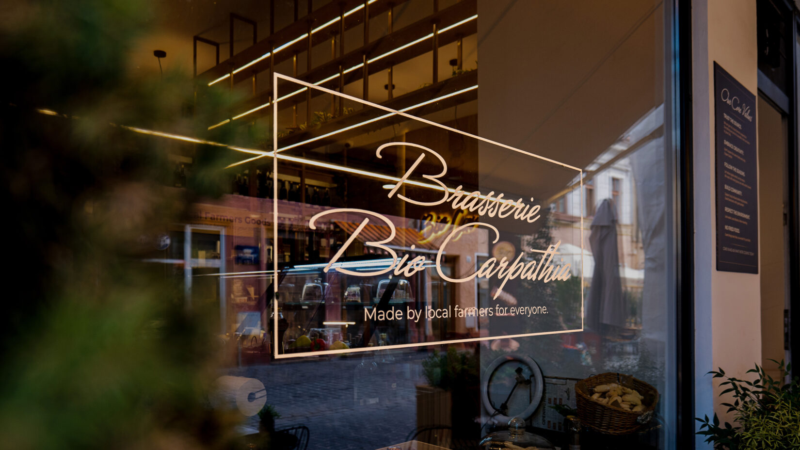 Grafica de pe geamul braseriei: Brasserie Bio Carpathia, Made by local farmers for everyone