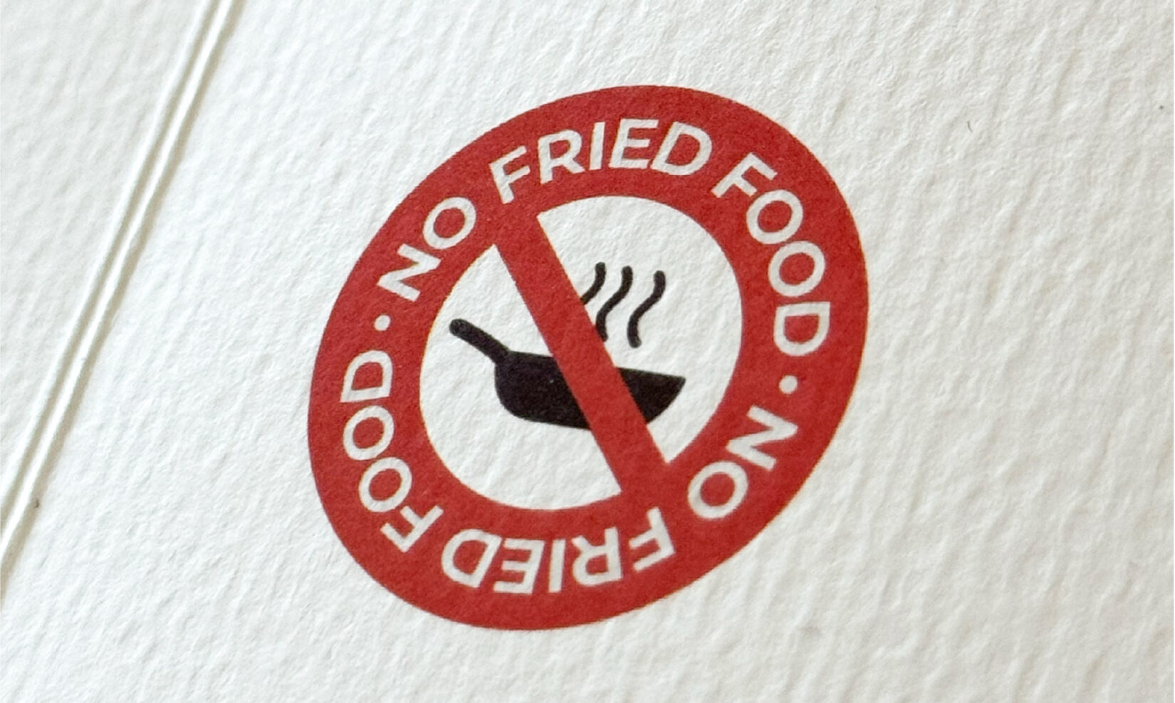 Simbolul No fried food tipărit în roșu pe hârtia texturată a meniului