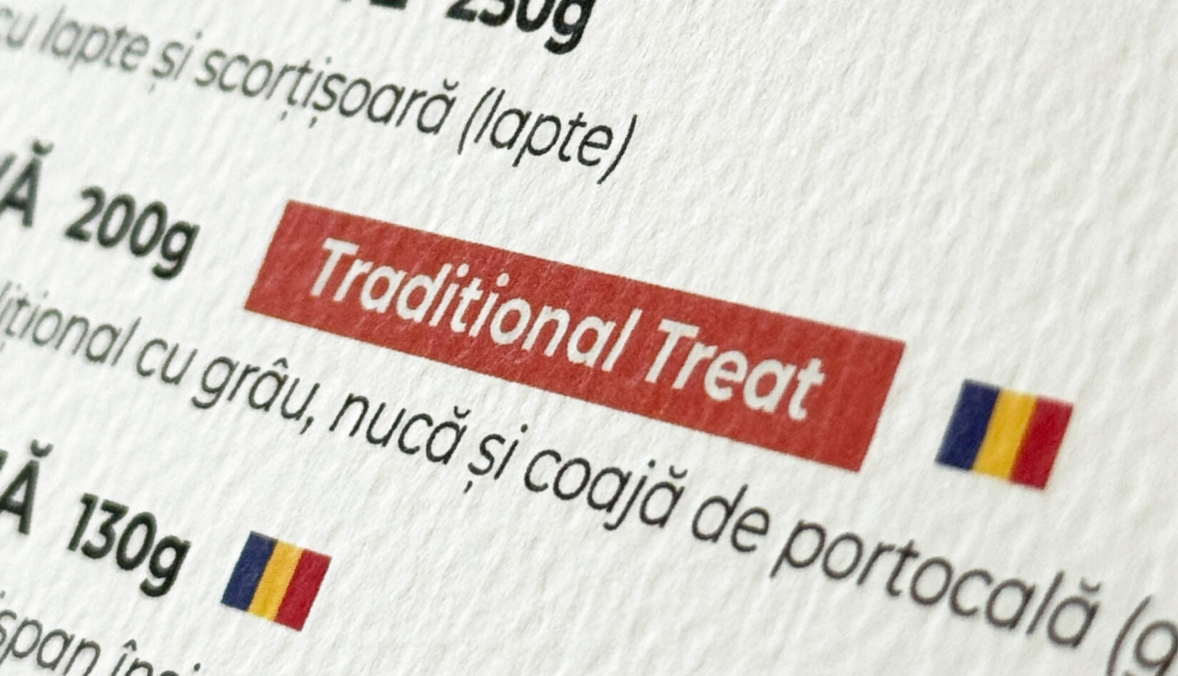 Detaliu din meniu, cu eticheta Traditional Treat și steagul României lângă preparat