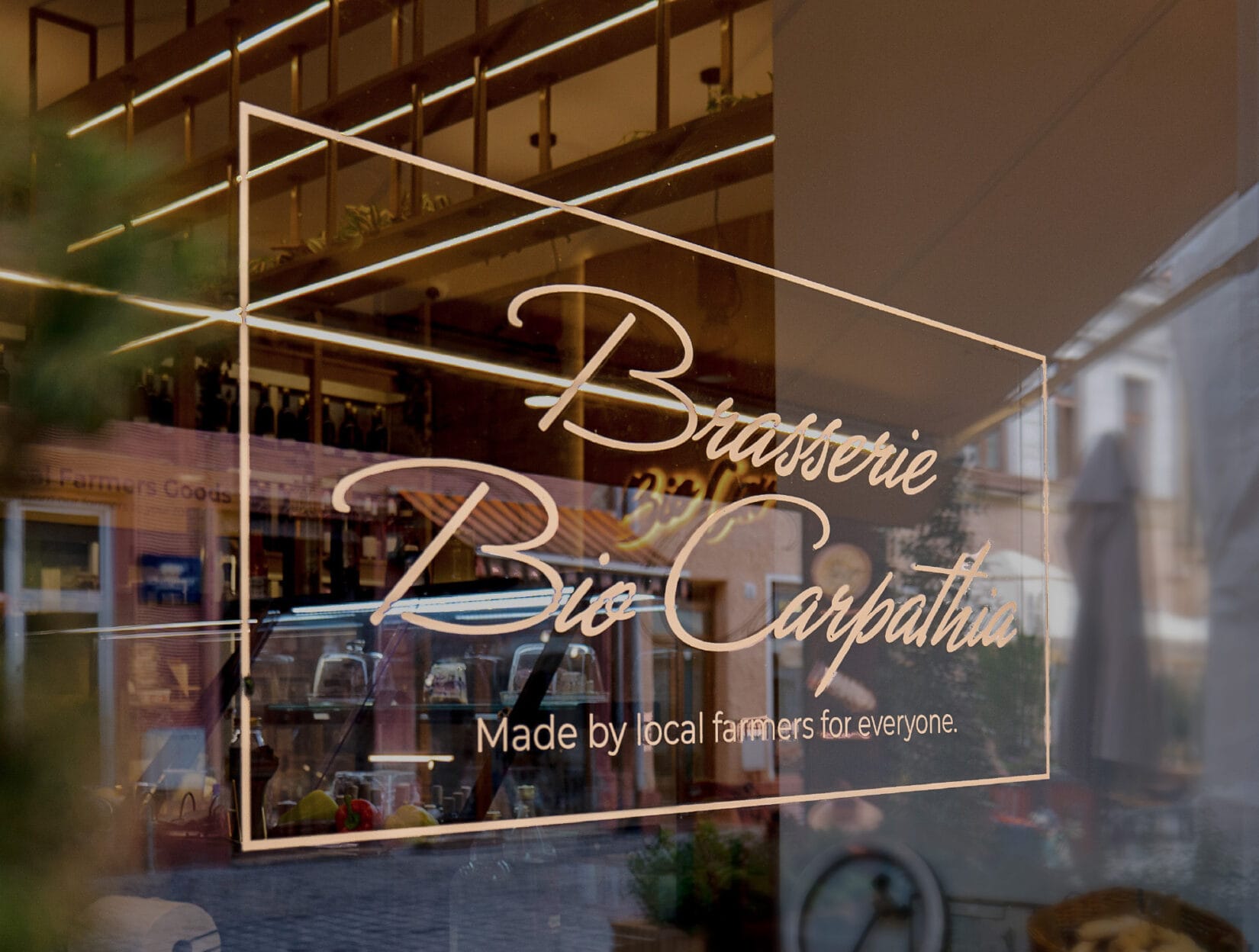Inscripția Brasserie Bio Carpathia aplicată pe geamul braseriei