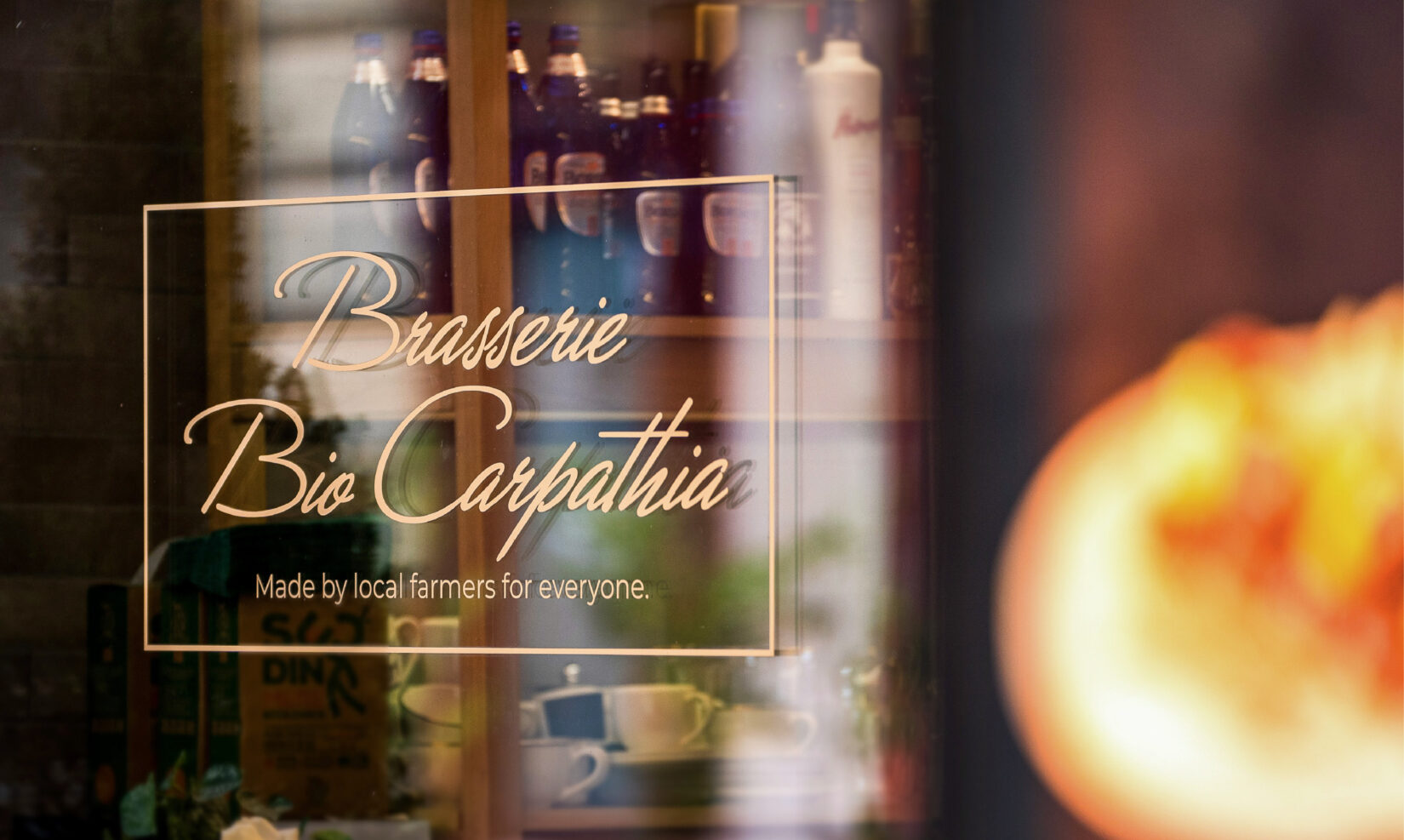 Grafica de pe geamul braseriei: Brasserie Bio Carpathia, Made by local farmers for everyone