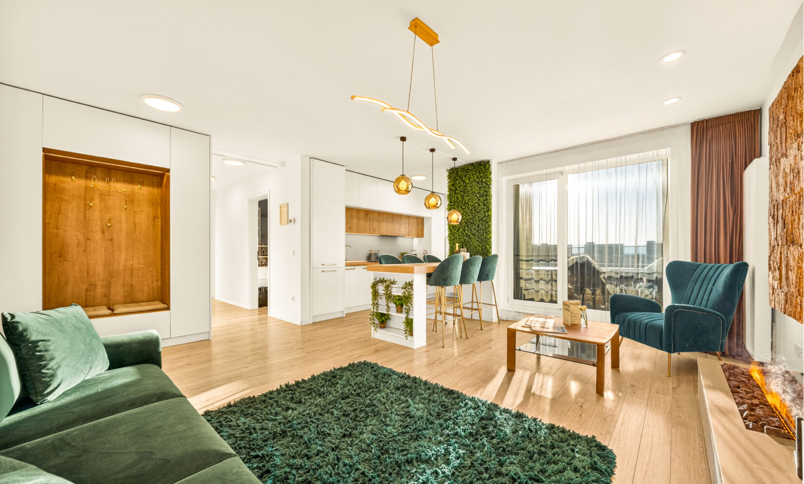 Livingul apartamentului Cliché Luxury, cu peretele din plută, bucătăria deschisă și canapeaua din catifea verde
