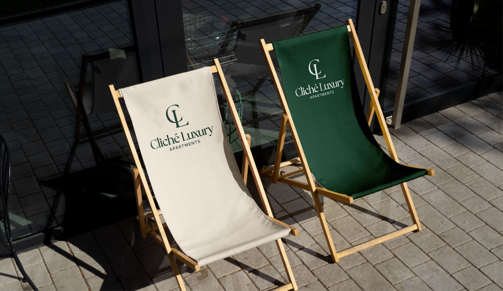 Logo-ul Cliché Luxury aplicat pe pânza a două șezlonguri, una albă și una verde
