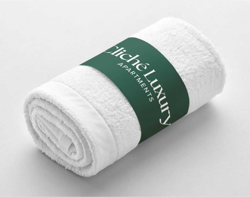 Prosop alb rulat, cu o banderolă verde cu logo-ul Cliché Luxury